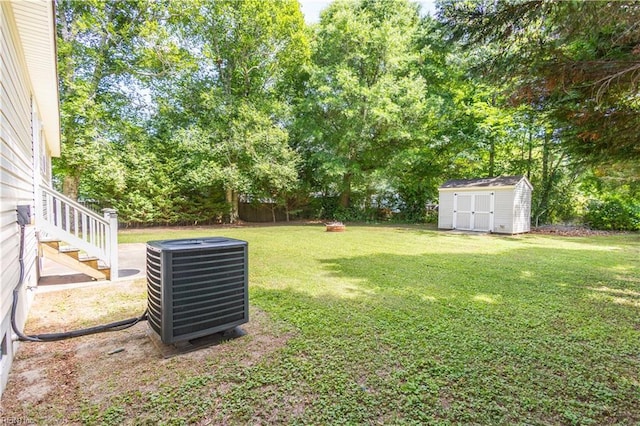 123 Willow Dr, Moyock, NC 27958 - view of green lawn with central AC unit, a storage shed, an outbuilding, and view of scattered trees