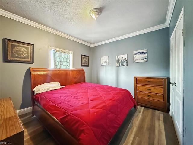 bedroom with baseboards, wood finished floors, ornamental molding, and a textured ceiling