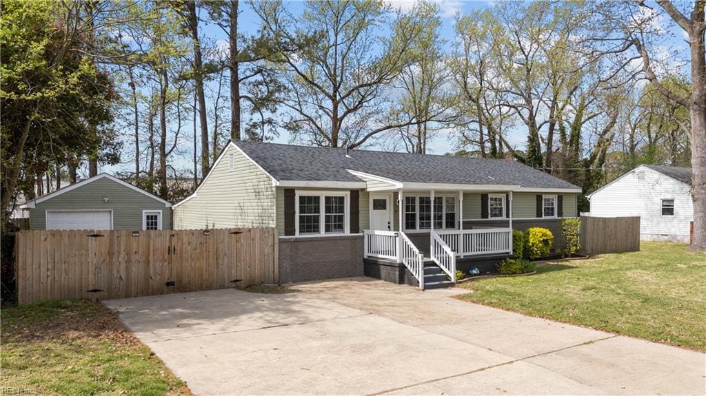 view of front of home featuring fence, a front yard, brick siding, a shingled roof, and a porch