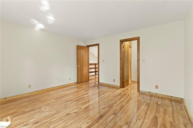 empty room with baseboards and light wood-style floors