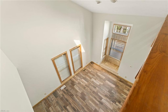 stairway featuring wood finished floors and visible vents