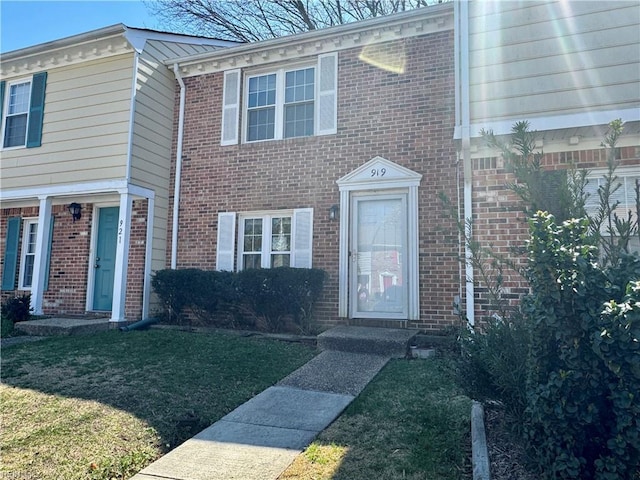 view of front of home featuring brick siding and a front yard