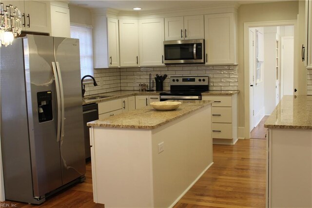 kitchen featuring tasteful backsplash, dark wood finished floors, a sink, white cabinets, and appliances with stainless steel finishes