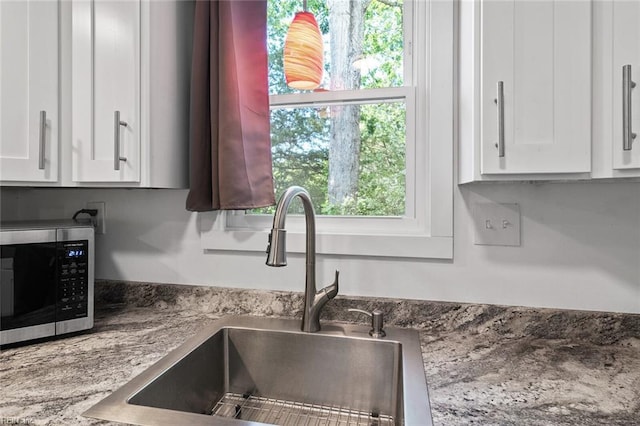 33 Mennonite Ln, Newport News, VA 23602 - details with white cabinets, a sink, and stainless steel microwave