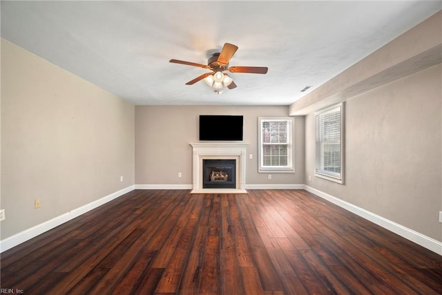 unfurnished living room with a ceiling fan, a fireplace with flush hearth, baseboards, visible vents, and dark wood-type flooring