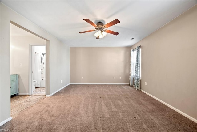 empty room with baseboards, visible vents, carpet flooring, and a ceiling fan