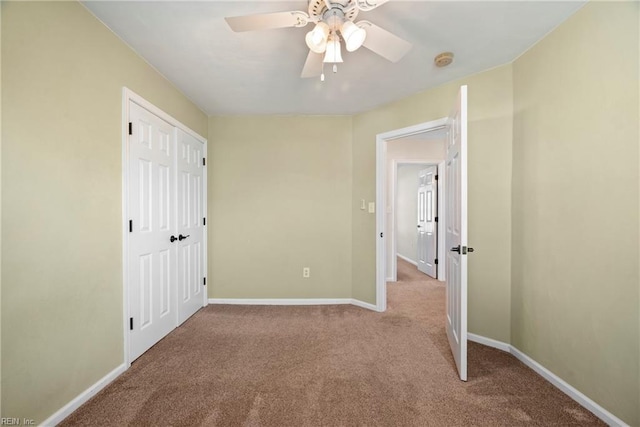 unfurnished bedroom featuring a ceiling fan, a closet, carpet, and baseboards