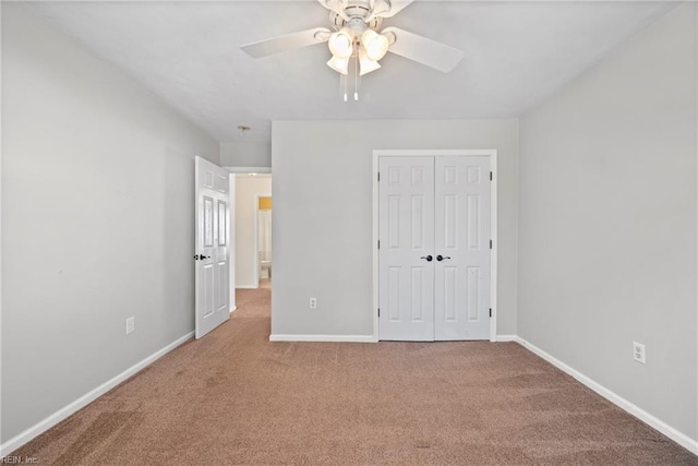 unfurnished bedroom with baseboards, a ceiling fan, a closet, and carpet