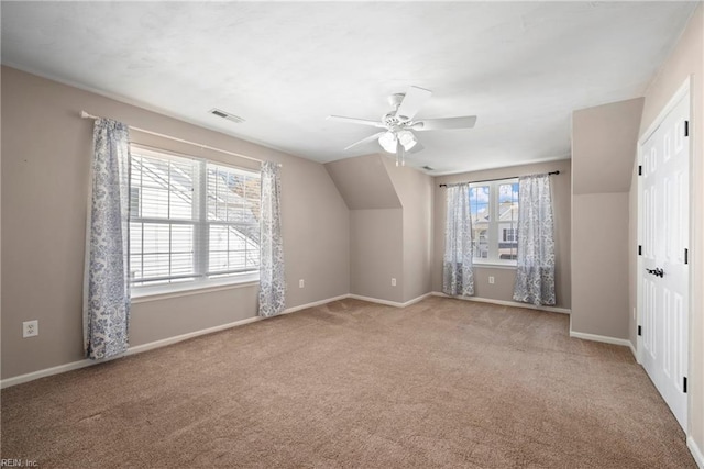 additional living space featuring carpet, baseboards, ceiling fan, and visible vents