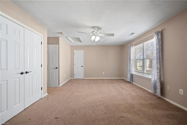 unfurnished bedroom with a closet, a ceiling fan, baseboards, light colored carpet, and visible vents