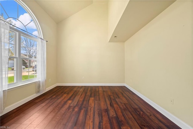 additional living space with baseboards, lofted ceiling, and dark wood-style flooring