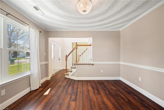spare room featuring hardwood / wood-style floors, baseboards, stairway, and crown molding