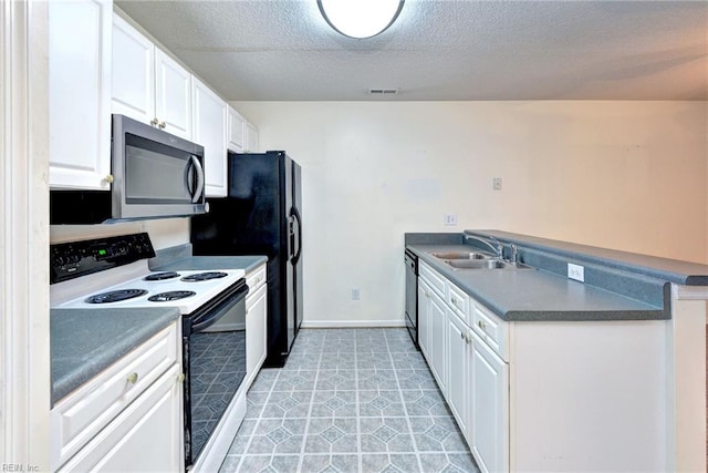 kitchen with stainless steel microwave, white cabinetry, electric range, visible vents, and a sink