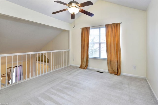 empty room featuring baseboards, a ceiling fan, carpet flooring, and lofted ceiling