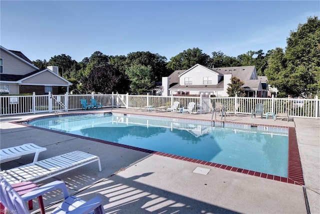 community pool featuring a patio and fence