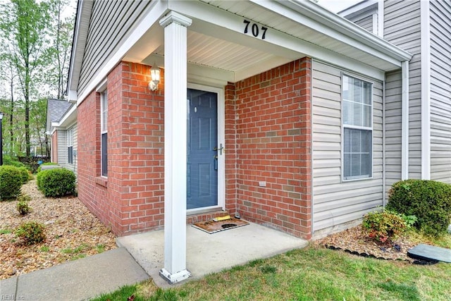 doorway to property with brick siding