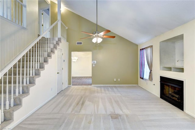 unfurnished living room featuring carpet flooring, ceiling fan, visible vents, and stairs