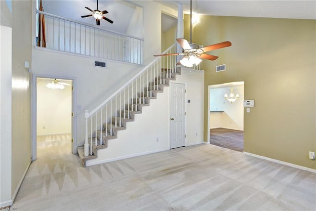 staircase with ceiling fan with notable chandelier, visible vents, and carpet floors
