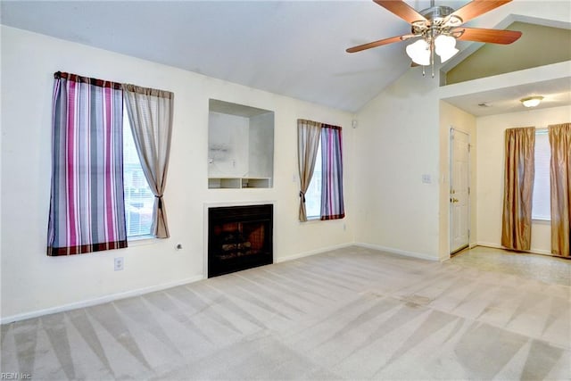 unfurnished living room with a fireplace, a ceiling fan, vaulted ceiling, carpet flooring, and baseboards