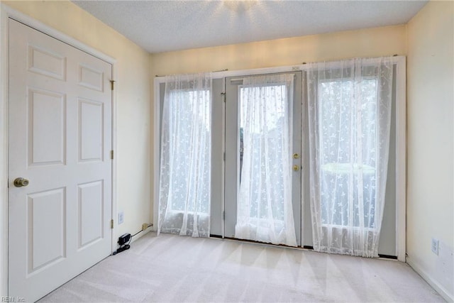 carpeted spare room with a textured ceiling