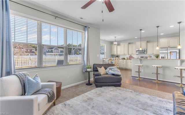 living room featuring baseboards, ceiling fan, and recessed lighting