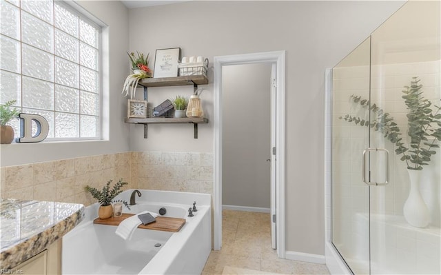 full bath with a shower stall, baseboards, and a bath