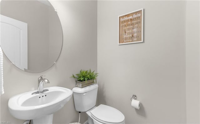 half bathroom with toilet and a sink
