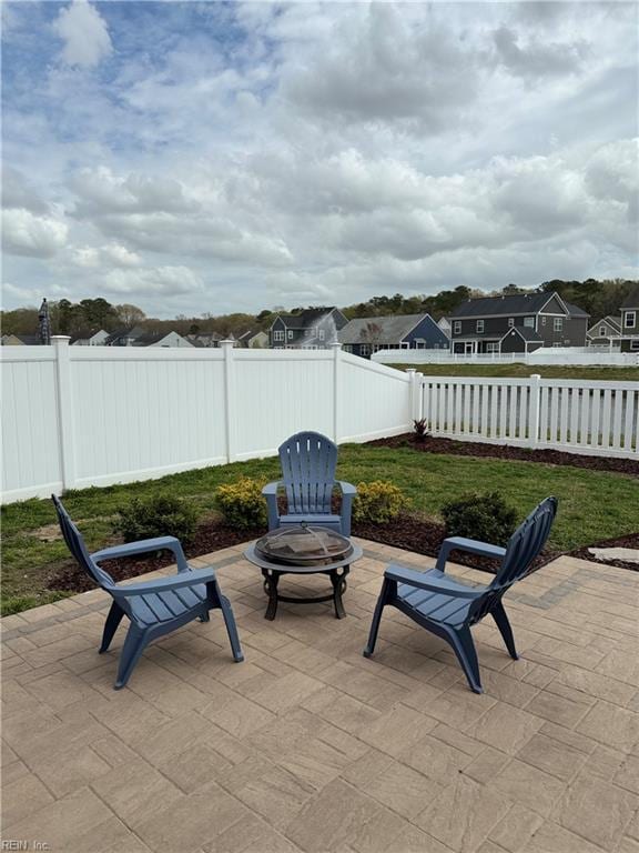 view of patio / terrace with a fire pit, a fenced backyard, and a residential view