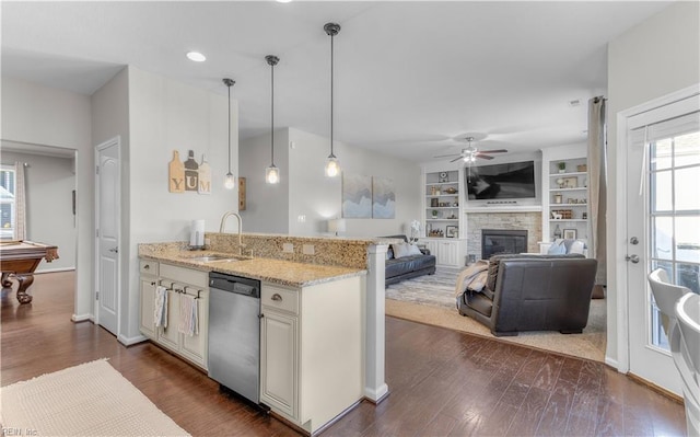 kitchen with a sink, dark wood-style floors, light stone counters, ceiling fan, and dishwasher