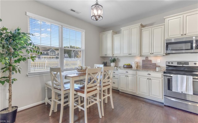 kitchen featuring dark wood-style flooring, visible vents, baseboards, light stone countertops, and appliances with stainless steel finishes