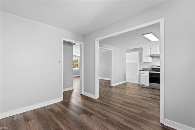 unfurnished living room with dark wood-style flooring and baseboards