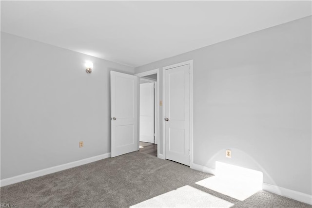 carpeted empty room featuring baseboards