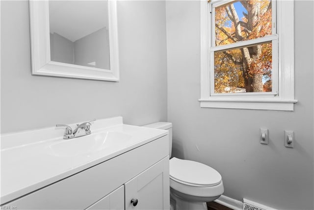 bathroom featuring toilet, vanity, and a baseboard radiator