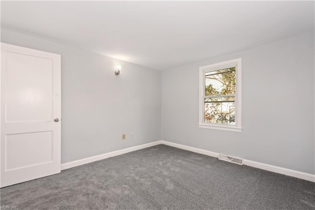 carpeted empty room featuring baseboards and visible vents