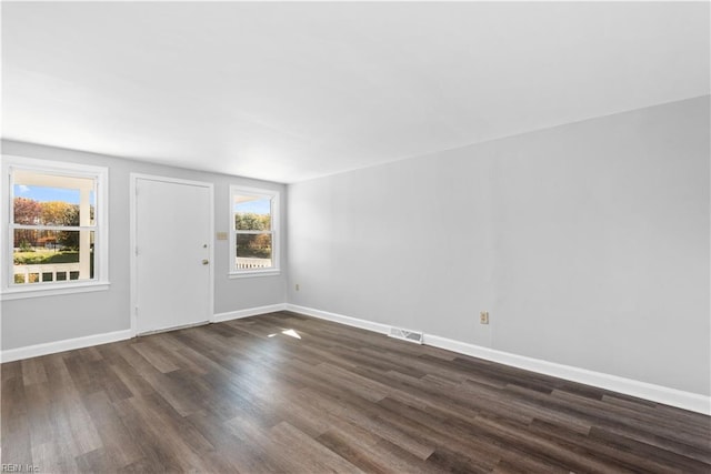 entrance foyer featuring dark wood-style flooring, baseboards, a healthy amount of sunlight, and visible vents
