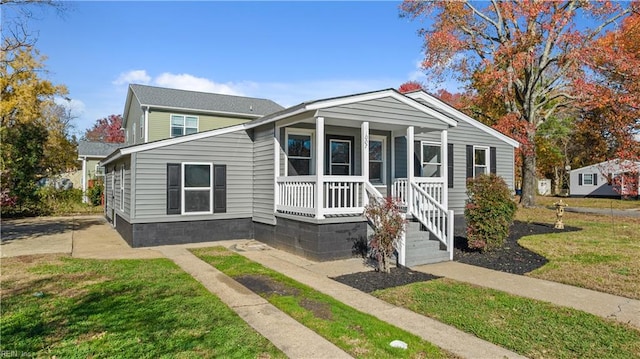 bungalow-style home with a front yard and covered porch