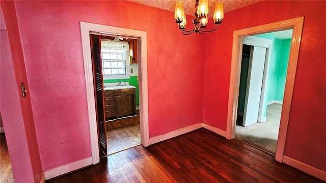 380 Hobson Ave, Hampton, VA 23661 - unfurnished dining area featuring baseboards, a sink, dark wood-type flooring, and a chandelier