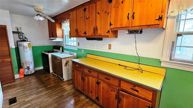 380 Hobson Ave, Hampton, VA 23661 - kitchen with gas water heater, dark wood-style floors, visible vents, white range with gas stovetop, and brown cabinetry