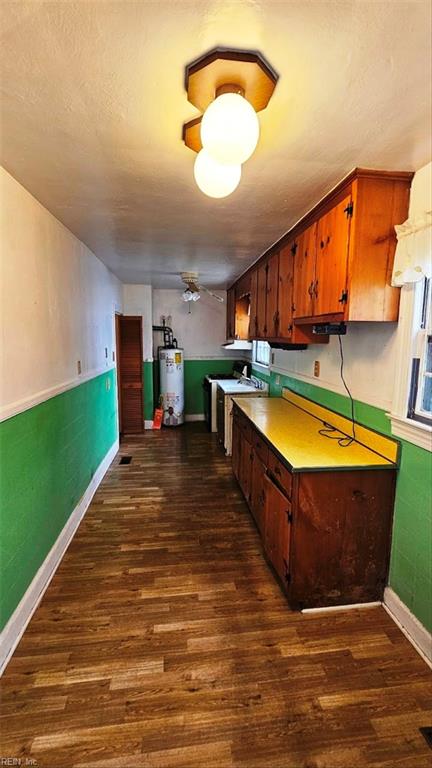 380 Hobson Ave, Hampton, VA 23661 - kitchen with a textured ceiling, gas water heater, dark wood-style floors, wainscoting, and baseboards