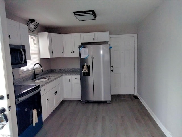 901 37th St, Newport News, VA 23607 - kitchen with freestanding refrigerator, range with electric stovetop, wood finished floors, and white cabinetry
