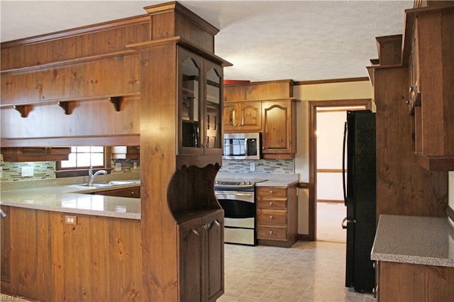kitchen featuring a sink, brown cabinets, stainless steel appliances, decorative backsplash, and ornamental molding