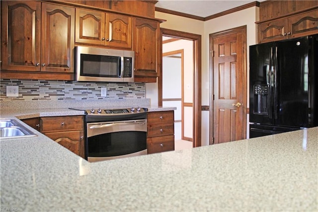 kitchen featuring crown molding, backsplash, light countertops, and appliances with stainless steel finishes