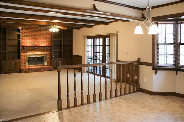 interior space featuring baseboards, beam ceiling, a ceiling fan, built in features, and a fireplace