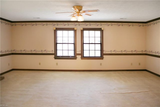unfurnished room with baseboards, ceiling fan, ornamental molding, and light colored carpet