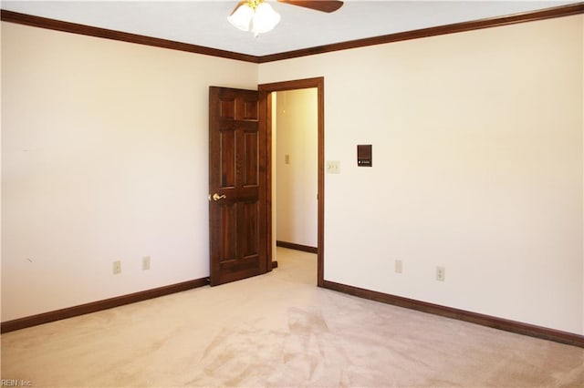 unfurnished room with a ceiling fan, ornamental molding, baseboards, and light colored carpet