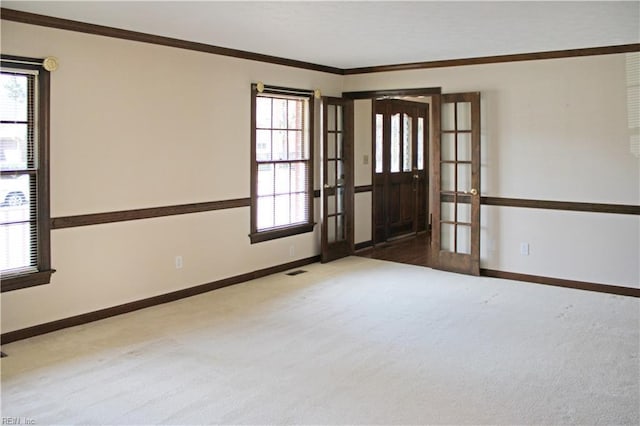 spare room with ornamental molding, carpet floors, and french doors