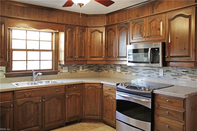 kitchen with light countertops, a sink, tasteful backsplash, stainless steel appliances, and ceiling fan