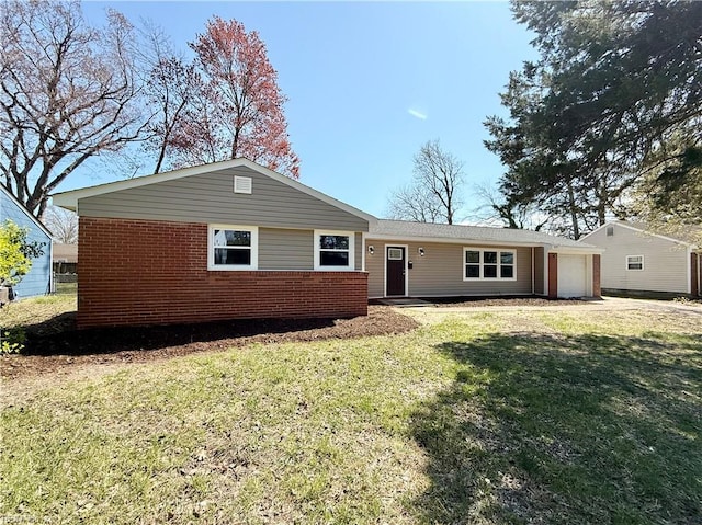 view of front of home with brick siding, a front yard, and an attached garage