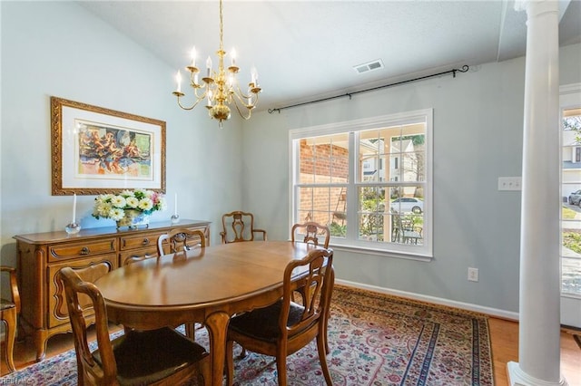 dining space featuring decorative columns, visible vents, a wealth of natural light, and an inviting chandelier