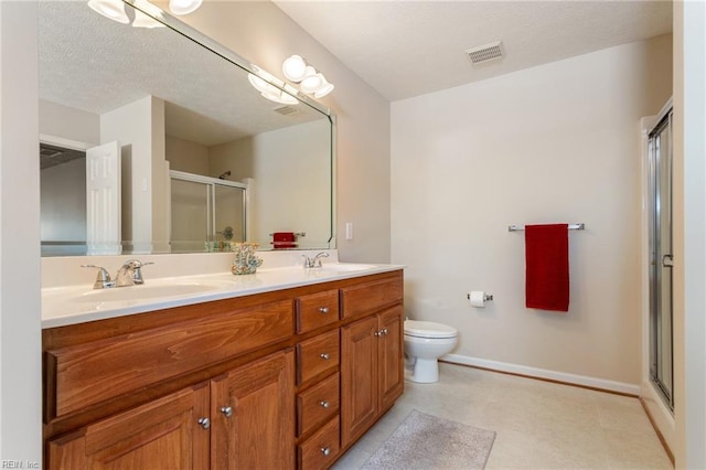 full bath featuring a stall shower, a sink, baseboards, visible vents, and double vanity